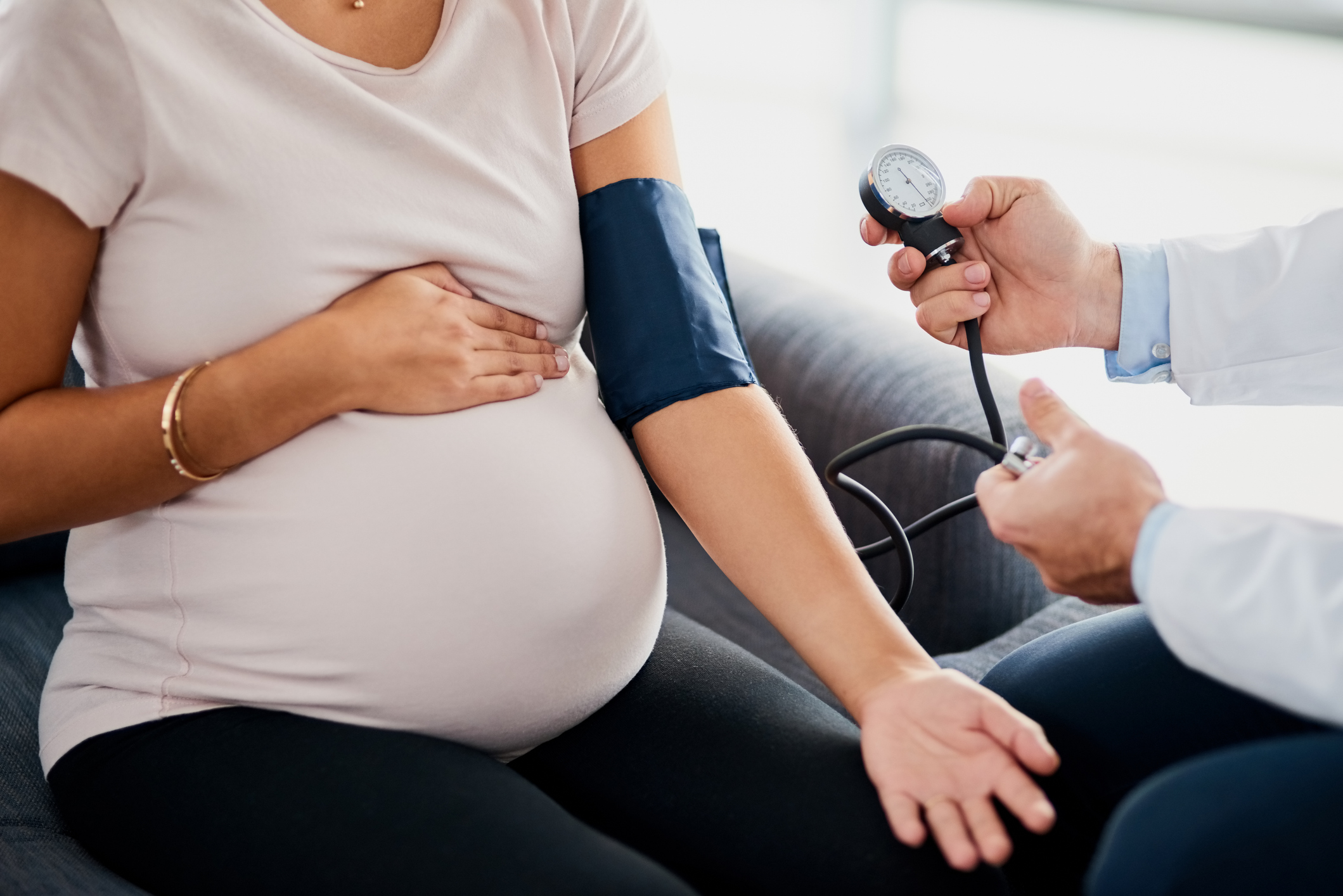 A clinician measuring a pregnant patient's blood pressure